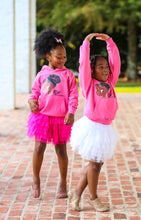 Image of two brown ballerinas wearing hoodie of Nia Ballerina face who is a black ballerina.